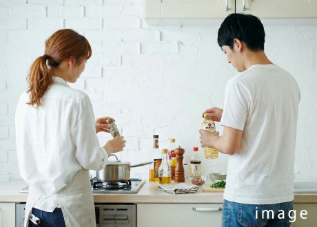 キッチンで作業する夫婦の後ろ姿イメージ写真